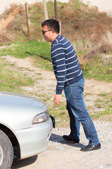 a man is repairing a car on the road