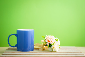 an empty pastel color mug with flower and retro clock