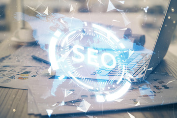 Multi exposure of table with computer and seo drawing hologram. Search optimization concept.