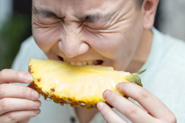 man eating pineapple