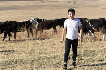 man and cow on pasture