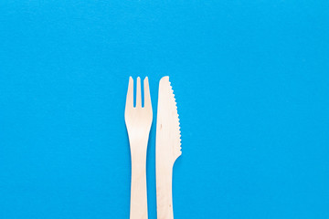 Forks Cutlery on a bright blue background. Eco-friendly wooden disposable cutlery on bright colored backdrop. Wallpapers for modern and ecological food. Plastic Free background for food banner