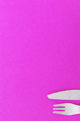 Fork and Knife. cutlery on a bright pink background. eco-friendly wooden cutlery isolated on a very bright colored backdrop. wallpapers for modern and ecological food.