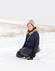 Fototapeta na wymiar Portrait of a beautiful girl in blue jackets on the background of snow. Outdoor winter portrait