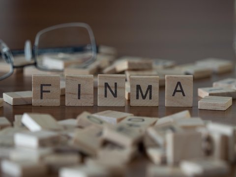the acronym finma for Swiss Financial Market Supervisory Authority (FINMA) concept represented by wooden letter tiles
