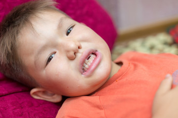 the boy laughs and shows the first tooth. children's teeth, loss and fingers are directed to the incisors, the baby’s mouths are close-up, the baby’s tooth cutter is absent