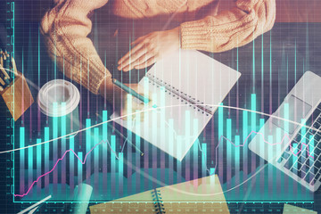 Forex graph on hand taking notes background. Concept of research. Double exposure