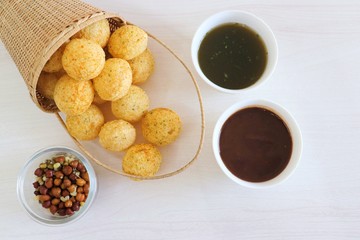 Panipuri or Golgappa. Indian street snack made of fried mint flavors puries, mint chutney, sprouts and dates, tamarind chutney. Indian Chat.