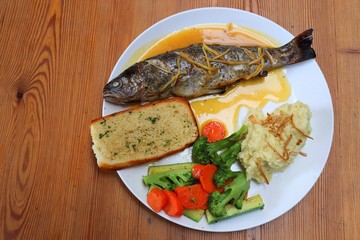 Fish dish - wood oven baked or roasted trout fish served with saute vegetables and mashed potato with copy space. Family meal