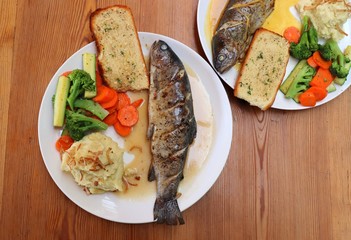 Fish dish - wood oven baked or roasted trout fish served with saute vegetables and mashed potato with copy space. Family meal