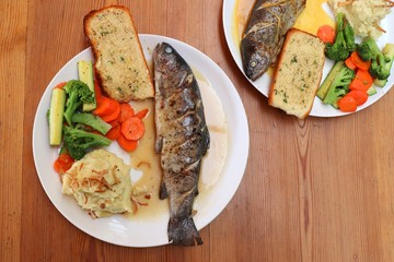 Fish dish - wood oven baked or roasted trout fish served with saute vegetables and mashed potato with copy space. Family meal