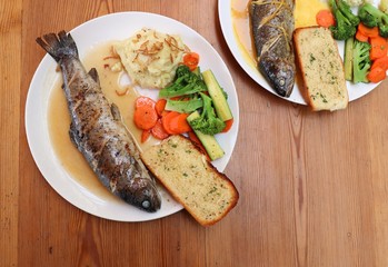 Fish dish - wood oven baked or roasted trout fish served with saute vegetables and mashed potato with copy space. Family meal
