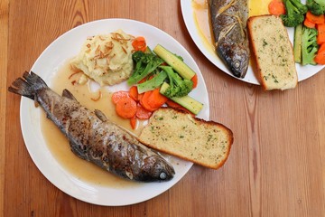 Fish dish - wood oven baked or roasted trout fish served with saute vegetables and mashed potato with copy space. Family meal