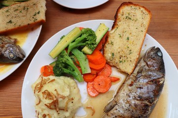 Fish dish - wood oven baked or roasted trout fish served with saute vegetables and mashed potato with copy space. Family meal