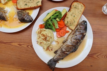 Fish dish - wood oven baked or roasted trout fish served with saute vegetables and mashed potato with copy space. Family meal