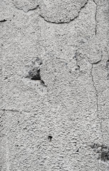 Cracked concrete grey wall covered with gray cement texture as background can be used in design. Dirty concrete texture with cracks and holes.