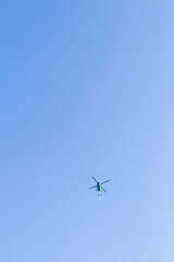 Green helicopter in the sky.