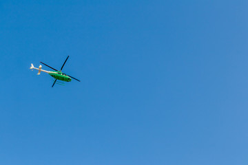 Green helicopter in the sky.