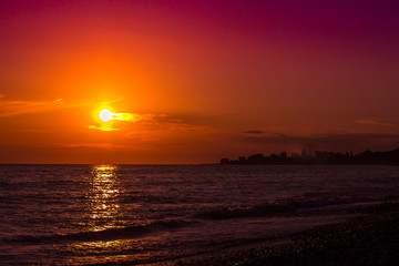 Fototapeta premium beautiful bright sunset on the sea with the coastline on the horizon