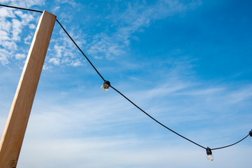 Close up of the light bulbs at the beach cafe terrace. Sunny summer day.