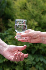 Hände geben sich fürsorglich ein Glas mit Wasser zum Trinken