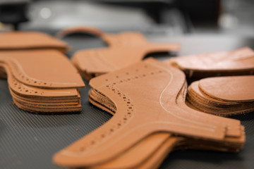 Different forms of leather pieces which will be use for making a shoes on a shoes factory. Prepared, bundled leather parts, used in the production of shoes.