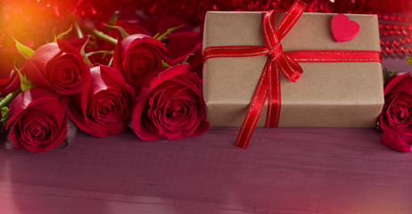 Graft gift package with red roses on colorful wooden background. Backgrounds for special days ( Valentine's Day, Wedding Anniversary, Mother's Day and Women's Day, birthday )