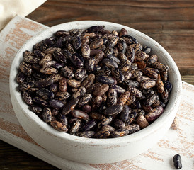 raw oval red marble beans in a plate on a wooden table