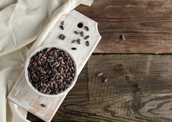 raw oval red marble beans in a plate on a wooden table