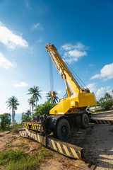 Yellow automobile crane with risen telescopic boom outdoors. Mobile construction crane on a...