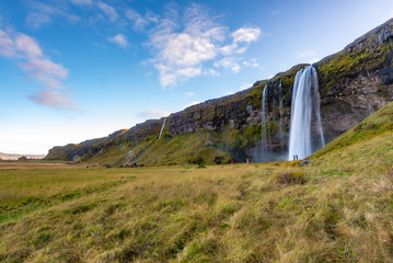 Seljalandfoss waterfall seen from afar with unrecognisable visitors, Iceland