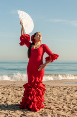 Young Spanish woman dancing flamenco on the beach
