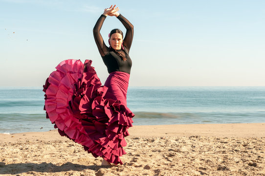 Young Spanish woman dancing flamenco on the beach