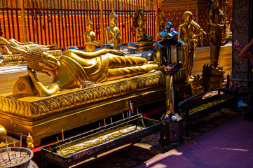 Laying golden Buddha with golden statues in the background