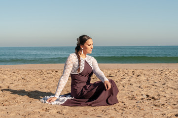 Young Spanish woman dancing flamenco on the beach