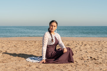 Young Spanish woman dancing flamenco on the beach