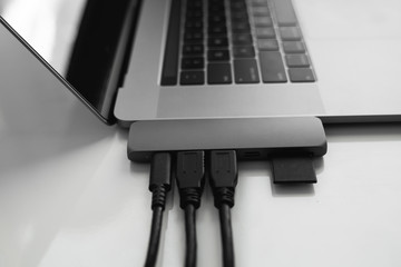 Laptop with USB Type-C adapter with pluged USB cables and SD card. The USB adapter under the Type-C...