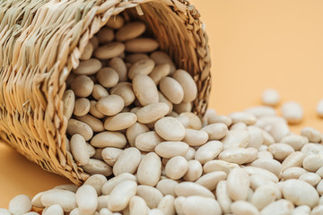 Healthy organic dried white beans in a straw basket