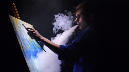 Obraz premium Artist copyist paint seascape with ship in ocean. Vaper smoke vape e-cigarette. Craftsman decorator draw as boat sail on blue sea with acrylic oil color. Draw finger, brush, knife palette. Indoor.