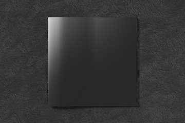 Black square brochure or booklet cover mock up on black background. Isolated with clipping path around brochure. View above.  3d illustratuion
