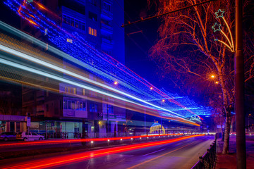 Blurred car lights in a long exposure traffic shot. Capturing the motion on the road of a city at night time. Urban landscape, quick pace, busy lives.