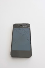 Smart phone with cracked screen over white background