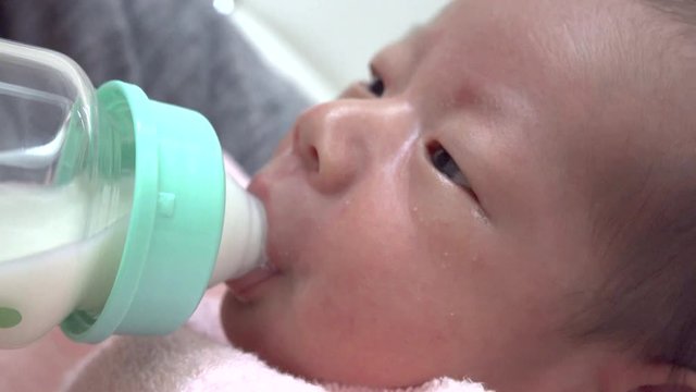 哺乳瓶でミルクを飲む新生児