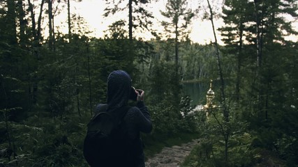 Traveler photographing scenic view in forest. One caucasian woman shooting nice magic look. Girl take photo video on dslr mirrorless camera. Professional photographer travel with backpack. Outdoor. - obrazy, fototapety, plakaty