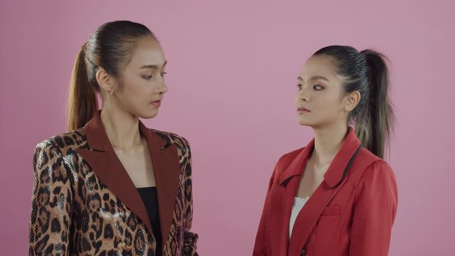Two Asian woman angry with each other push each other in physical conflict to start a fight