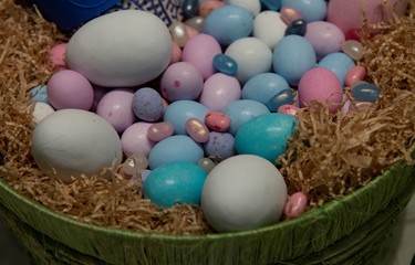 Fototapeta na wymiar Basket with multicolored Easter eggs of different sizes.