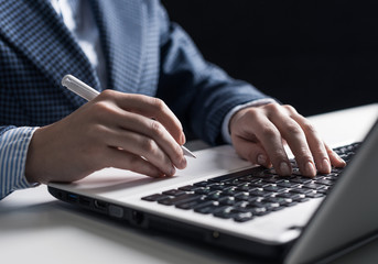 Man in business suit sitting at desk with laptop