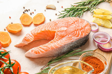 Fresh raw salmon, vegetables and spices on table