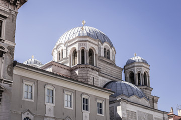 Fototapeta na wymiar Serbian orthodox Saint spyridon church (Chiesa di San Spiridione) in Trieste, Italy near the canal grande on the square saint antonio nuovo with the white domes and details of the cathedral.