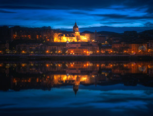 Fototapeta na wymiar Santa Maria church in Portugalete and reflections in Nervion river